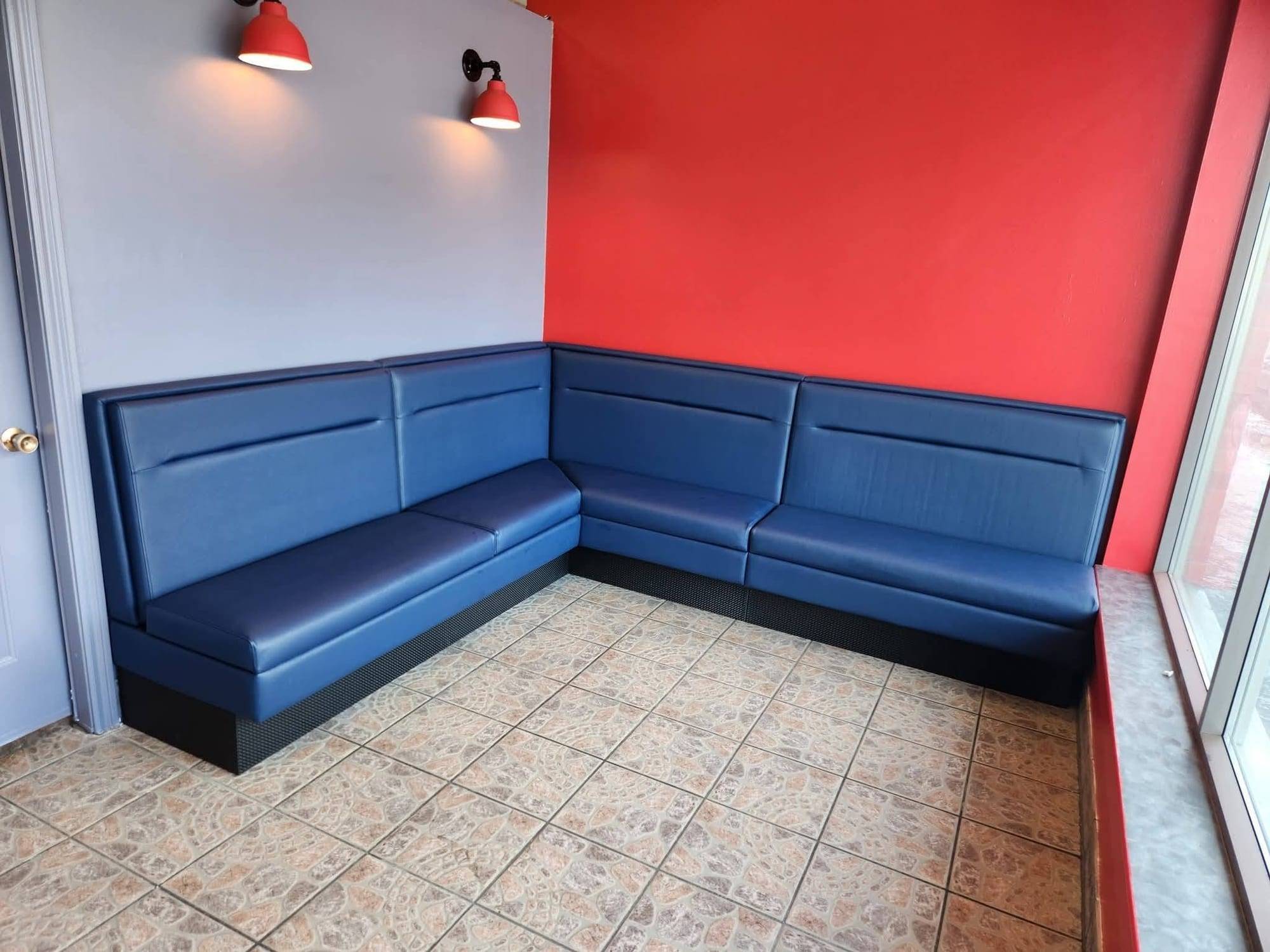 Banquette d'angle de restaurant en vinyle bleu marine, dossier à surpiqûre horizontale et base noire