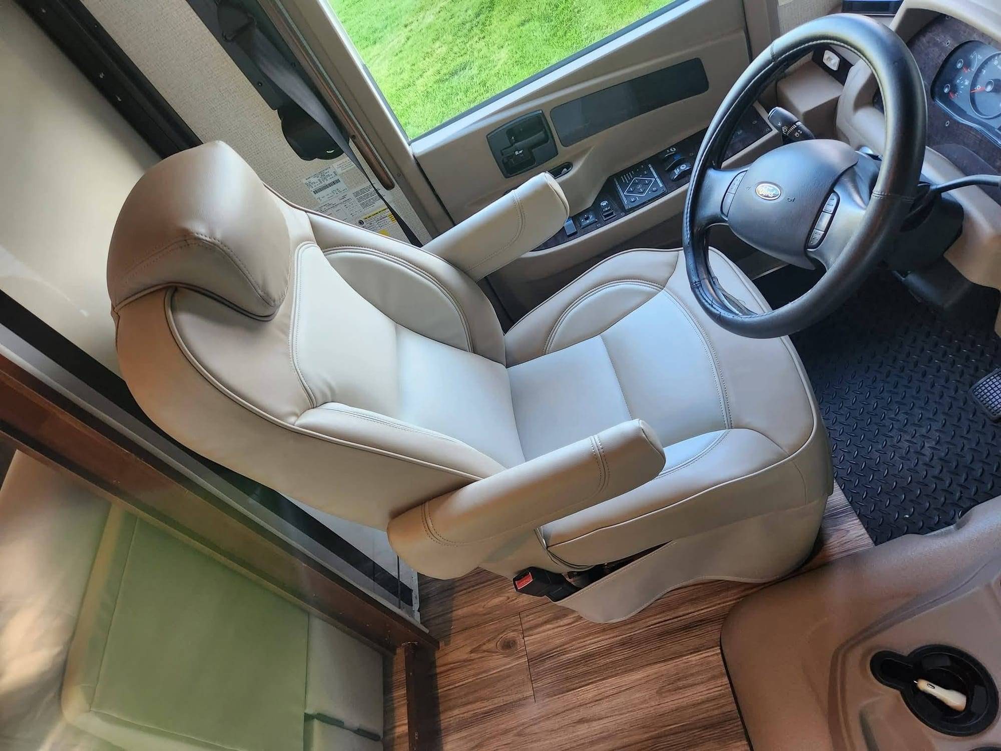 Fauteuil conducteur de VR recouvert de similicuir crème avec passepoil, réinstallé dans le véhicule