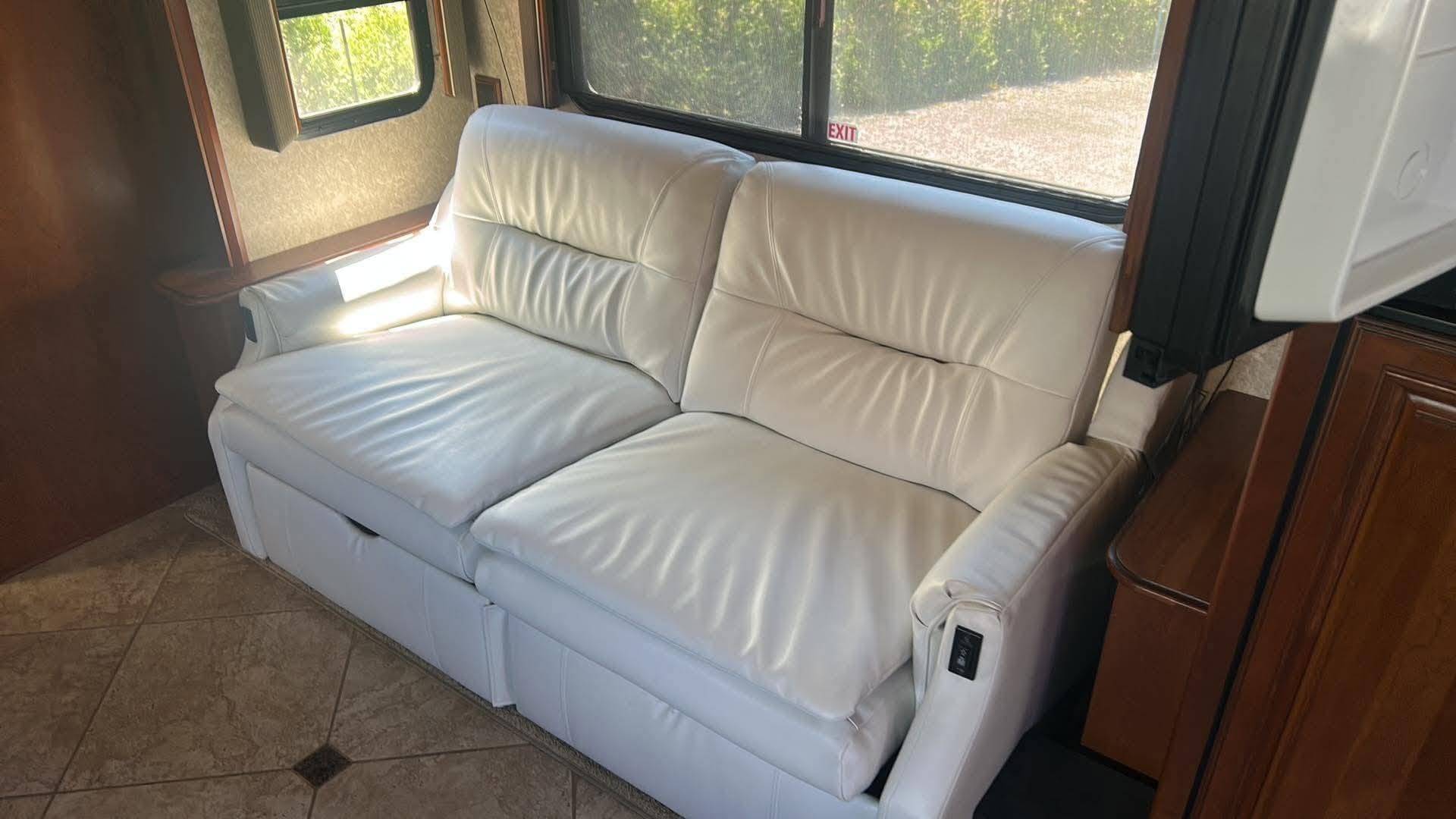 Sofa de VR recouvert de similicuir blanc, sous la fenêtre du véhicule