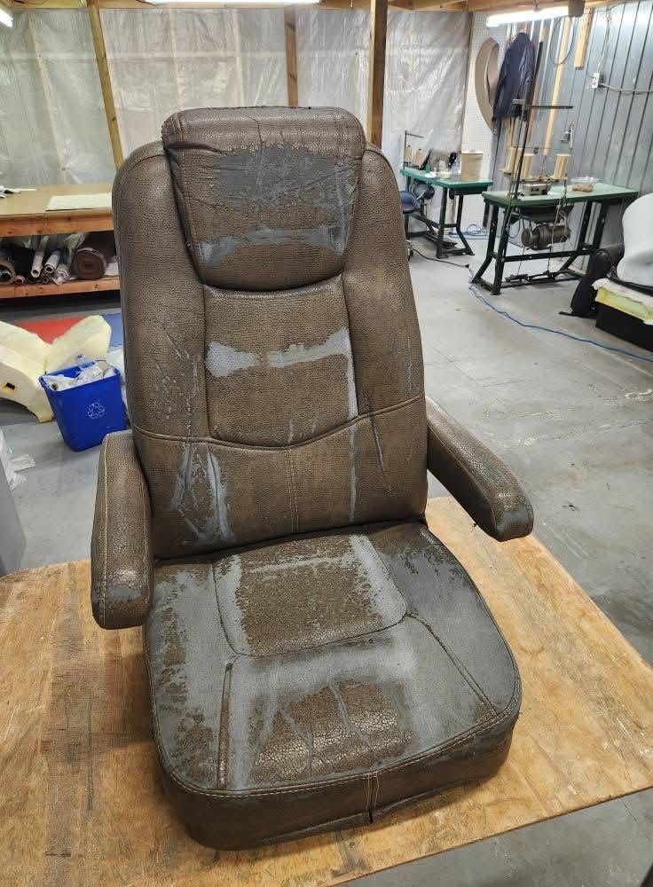 Fauteuil capitaine de VR au revêtement brun craquelé et décoloré, avant le rembourrage